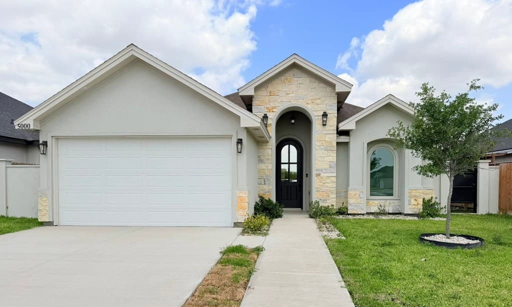 Stone and stucco home with arched entryway