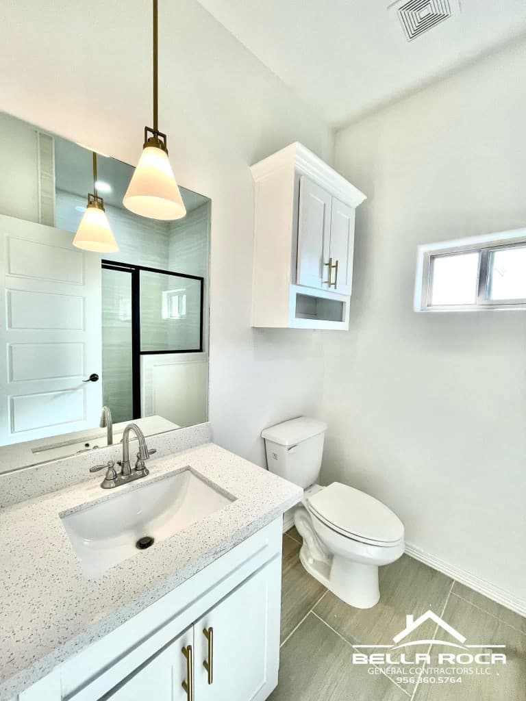 Renovated bathroom with white vanity and pendant lighting