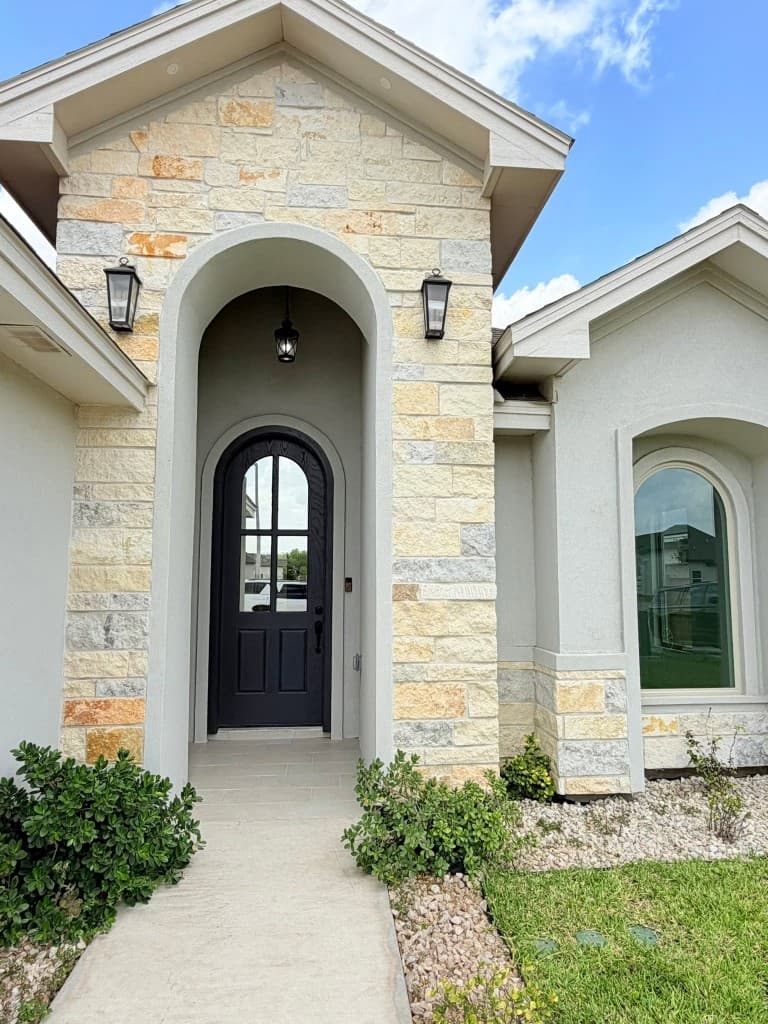 Arched stone entryway with decorative exterior lighting