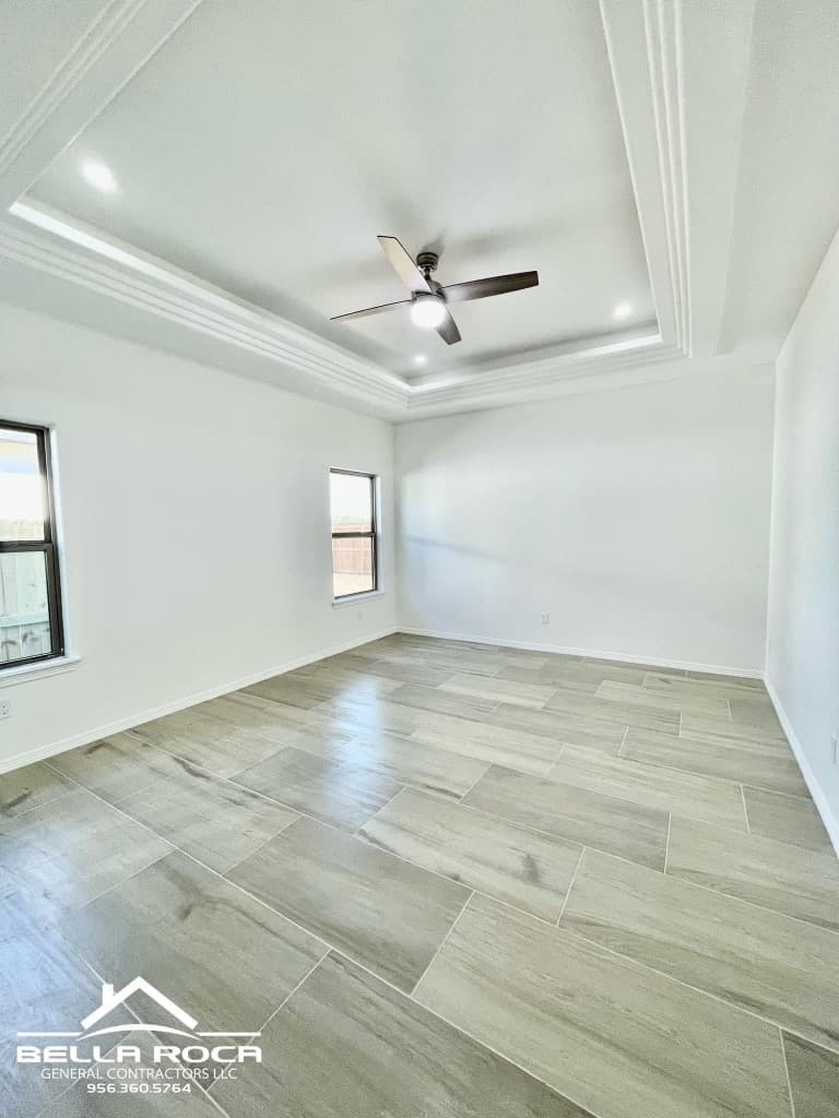 Bedroom with tray ceiling and wood-look tile flooring